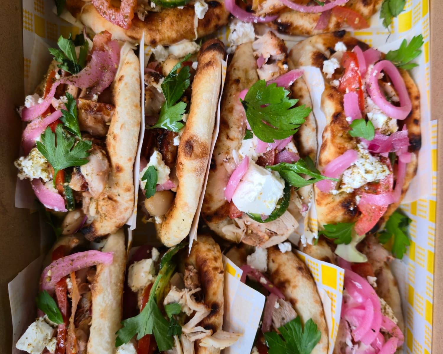 An Eat Ozzo catering box of Greek chicken Ozzos with pickled onion, feta and herbs for an Inner West event