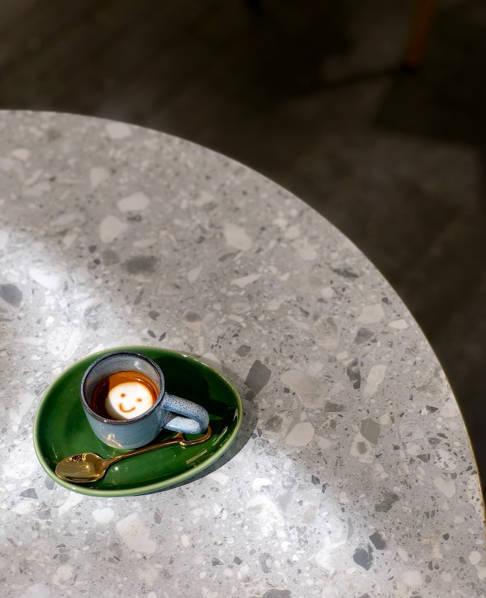 An espresso in a small blue cup on a green saucer at Eat Ozzo