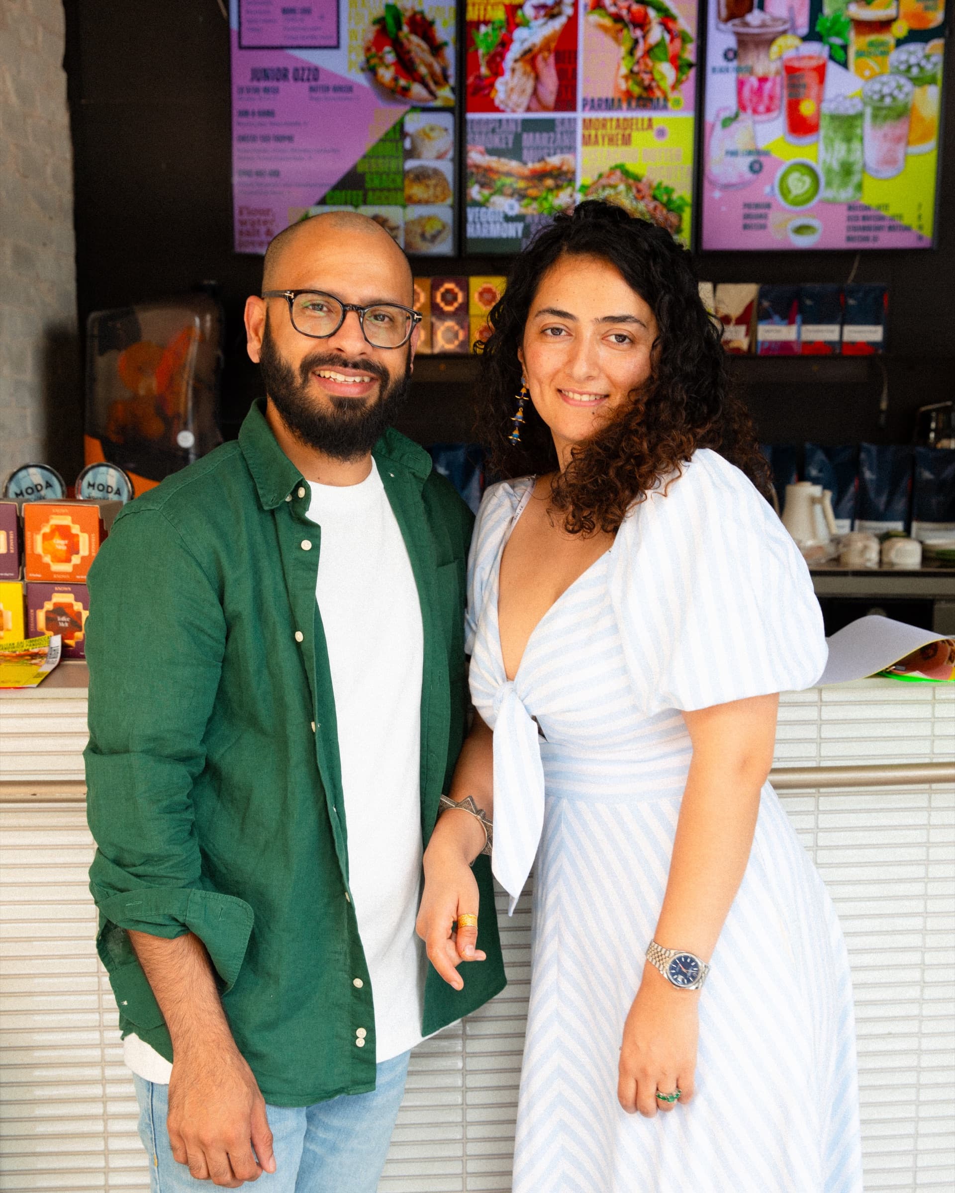 The Eat Ozzo founders at the counter, menu board behind them