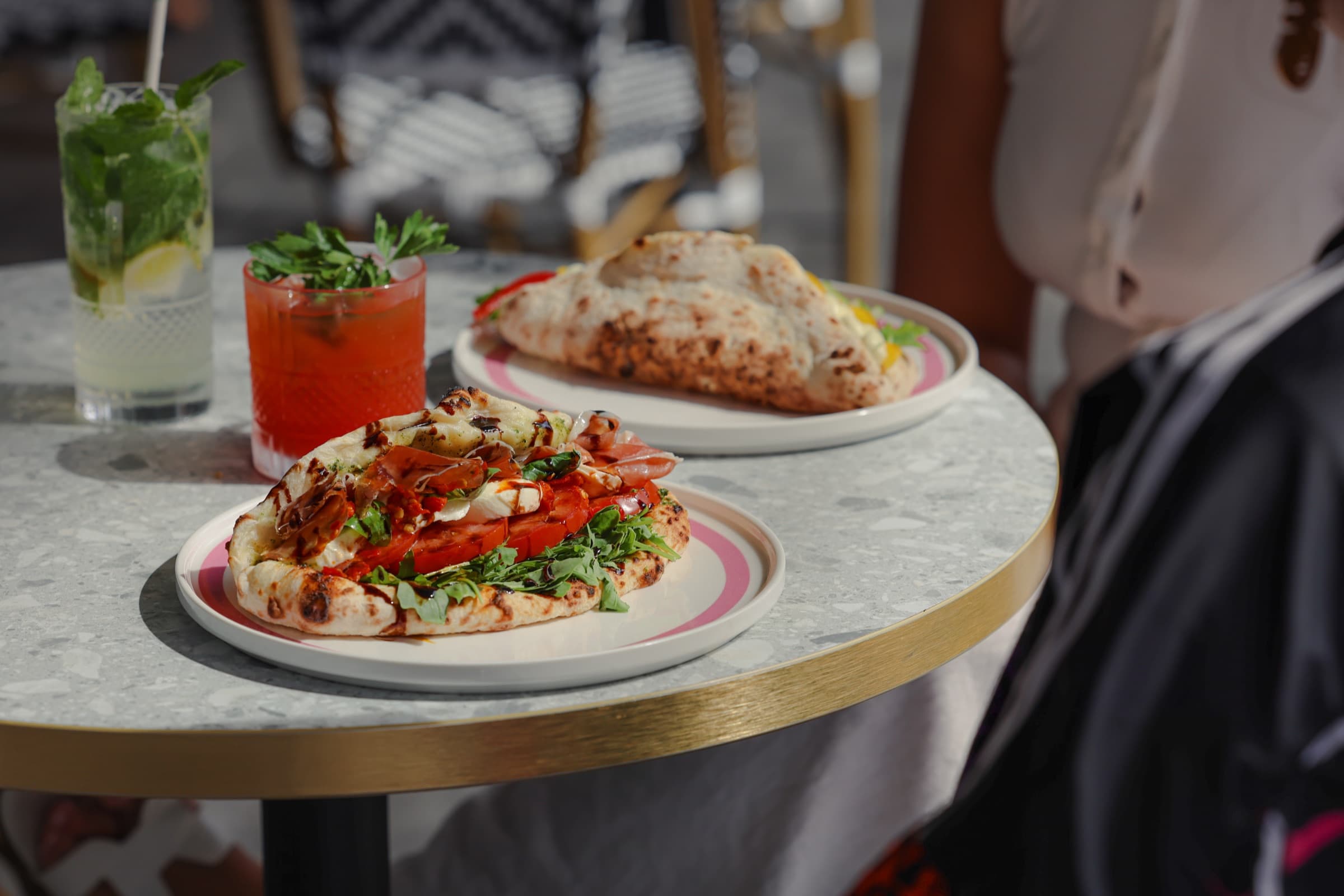 Pyrmont café table — pizzino, ozzo and bright drinks laid out under the harbour light