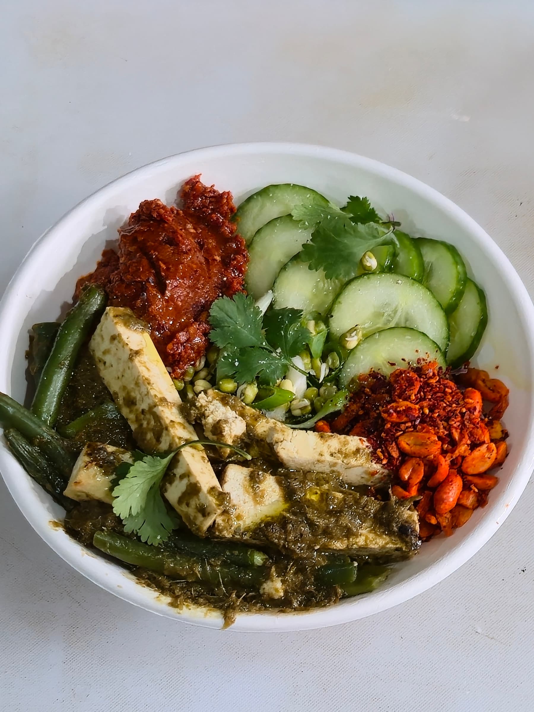 The Thai High bowl — green-curried tofu, peanut sambal, cucumber, sprouts, coriander