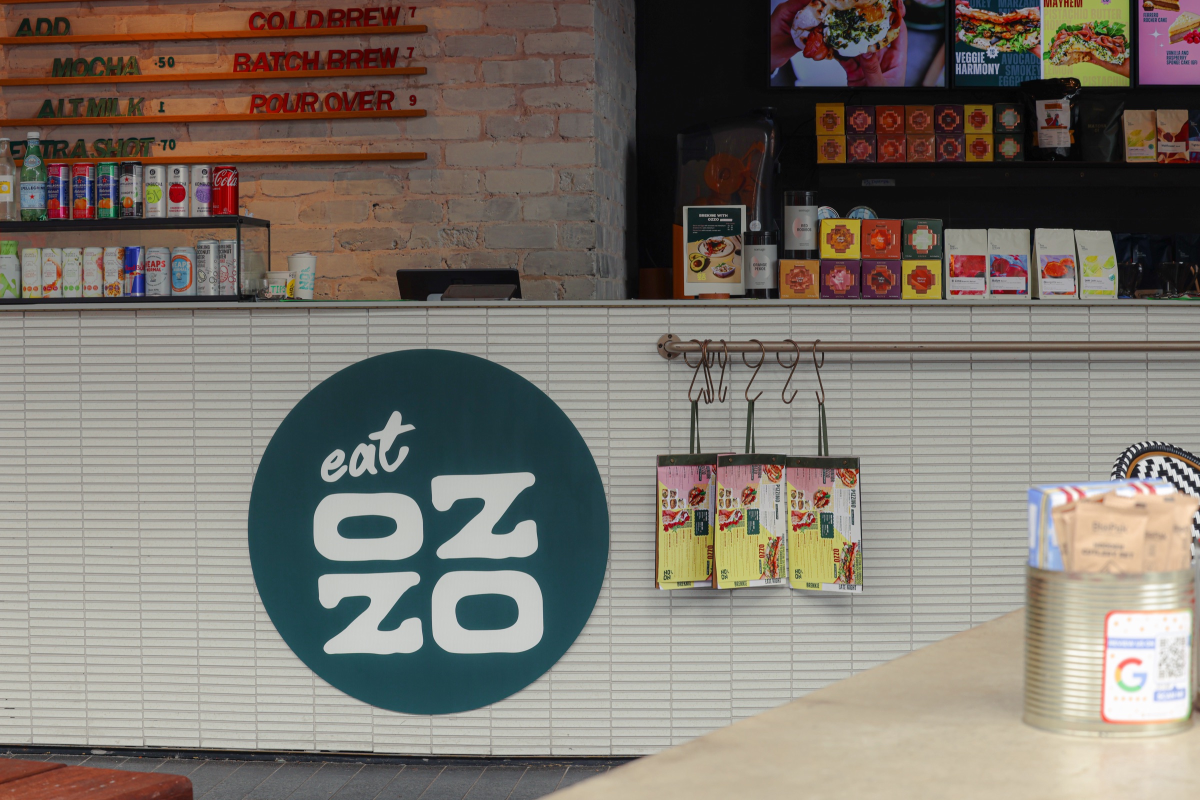 The Eat Ozzo counter in Pyrmont, warm light over the coffee machine and the day's bread